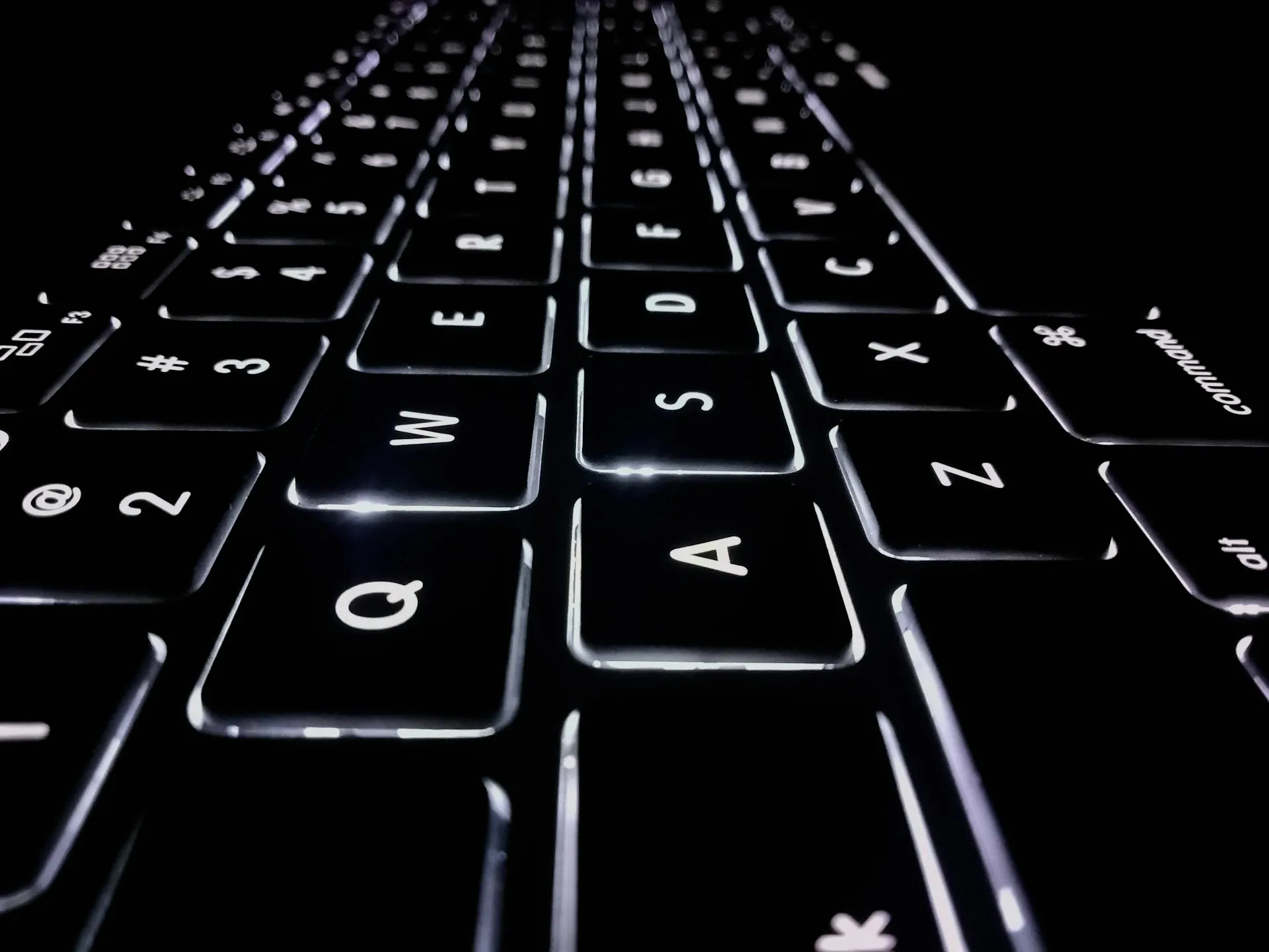 Backlit computer keyboard glowing in the dark