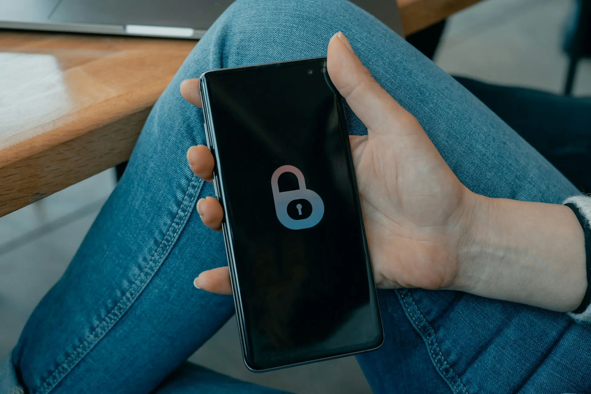 A hand holding a phone with a lock screen